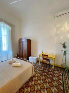 - une chambre avec un lit, un bureau et une table dans l'établissement 4 Balconi House-Appartamento salentino nel centro di Lecce, à Lecce