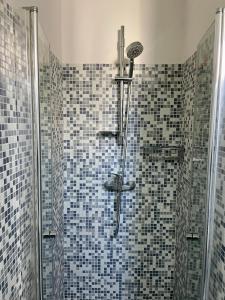 a bathroom with a shower with blue and black tiles at 4 Balconi House-Appartamento salentino nel centro di Lecce in Lecce