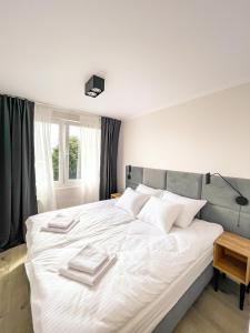 a bedroom with a large white bed with towels on it at Apartament IV piętro in Ustka