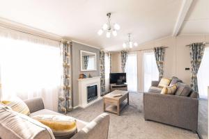 a living room with a couch and a tv at Audley Lodge with Hot Tub in York