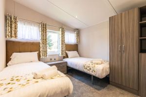 sypialnia z 2 łóżkami i oknem w obiekcie Audley Lodge with Hot Tub w mieście York