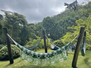 a hammock in a field with a mountain in the background at Vale do Lajeado - Mountain chalets in Campos do Jordão