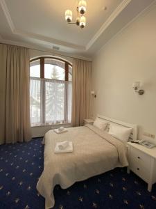 Un dormitorio con una cama grande y una ventana grande. en Готель Вілла Драгобрат, en Dragobrat