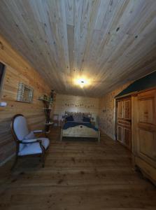 een kamer met een bed in een houten hut bij Les 3Crokignols, maison d’hôte familiale. in Saffloz