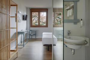 a bathroom with a sink and a table and a mirror at Hostal Rural Aritzalko in Echarri-Aranaz