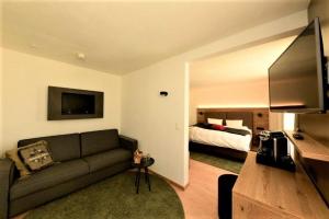 ein Wohnzimmer mit einem Sofa und einem Bett in der Unterkunft Hotel Bernina in Pontresina
