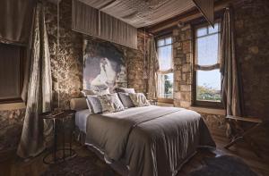 um quarto com uma cama num quarto com paredes de pedra em Area Synest Nature Suites em Sinevrón