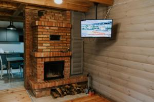 a living room with a brick fireplace with a tv at Zielone Zagrody -Dobra koło Sieniawy in Sieniawa