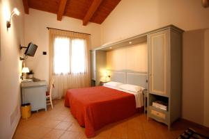 a bedroom with a large bed with a red blanket at Due Ponti Village in Cesenatico