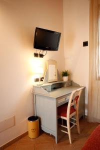 a desk with a computer and a monitor on a wall at Due Ponti Village in Cesenatico