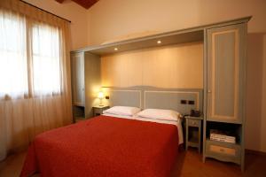 a bedroom with a large bed with a red bedspread at Due Ponti Village in Cesenatico