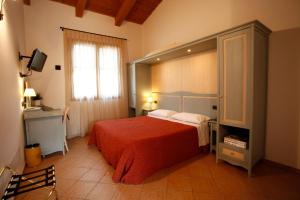 um quarto com uma cama grande e um cobertor vermelho em Due Ponti Village em Cesenatico