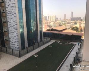 an aerial view of a building with a artificial grass at Lemas 1001 in Ajman 
