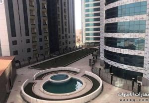 arial view of a building with a pool in the middle at Lemas 1001 in Ajman 