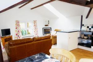 a living room with a couch and a table at Greenswood Cottage - Cosy cottage, rural location, beautiful landscaped gardens with pond and lake in Dartmouth