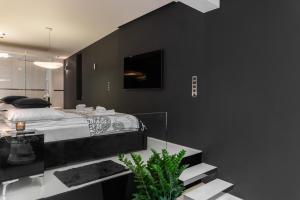 ビェルスコ・ビャワにあるApartament z jacuzzi City Life Centrumの黒い壁のベッドルーム1室(ベッド1台付)