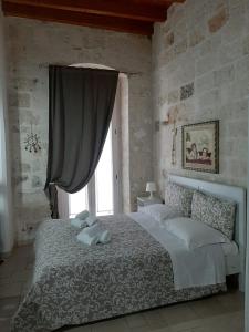 a bedroom with a large bed with a window at Casa Nave in Monopoli