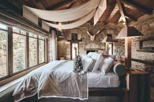 a bedroom with a bed with white sheets and pillows at Area Synest Nature Suites in Sinevrón