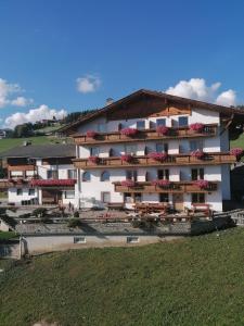 um grande edifício branco com flores nas varandas em Pension Lucknerhof em Maranza