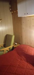 a bedroom with a red bed and a chair at Lago Rotondo Ski House in Mezzana