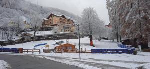 une ville enneigée avec un bâtiment en arrière-plan dans l'établissement Lago Rotondo Ski House, à Mezzana