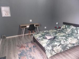 a bedroom with a bed and a desk and a table at TJ Self-catering in Graaff-Reinet