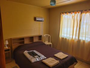 a bedroom with a bed with two towels on it at Cabañas Palo Blanco in Gobernador Costa