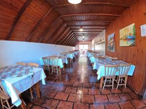 una fila di tavoli in una stanza con tavoli blu di Pousada Verde Agua a São Lourenço do Sul Altre 3 foto