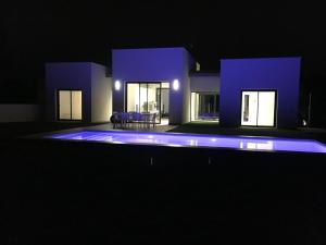 ein nachts beleuchtetes Haus mit Pool in der Unterkunft Villa Acacia in Orihuela