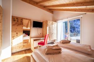 1 dormitorio con 2 camas, escritorio y ventana en Chalet de Ultimis, en San Pancrazio
