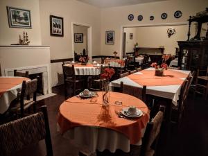 um restaurante com mesas e cadeiras e uma lareira em Pousada Casa Amarela em Piracaia