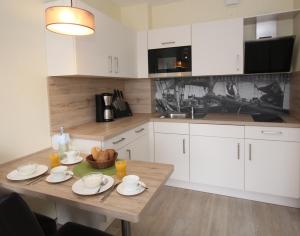 eine Küche mit einem Holztisch und weißen Schränken in der Unterkunft Appartementhaus Alt Büsum in Büsum