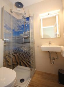 ein Bad mit einer Dusche, einem WC und einem Waschbecken in der Unterkunft Appartementhaus Alt Büsum in Büsum