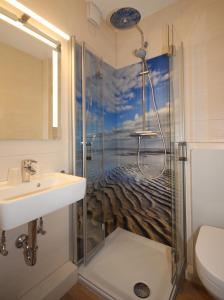 ein Bad mit einer Dusche und einem Waschbecken in der Unterkunft Appartementhaus Alt Büsum in Büsum