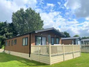 a small house with a fence in a yard at The Yorkshire Burrow Lodge with Hot Tub in York