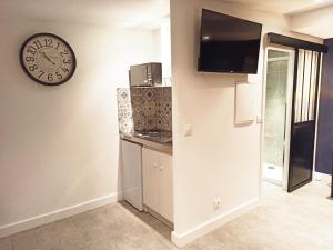 a kitchen with a clock on the wall and a counter at Studio Chaleureux in Pont-sur-Seine