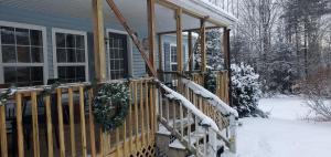 um alpendre de uma casa com neve em Chandler Hill Base Camp - Enjoy A Nature Getaway in this Rustic Home in the Mountains, 10 minutes from Sunday River Ski Mountain! home em Bethel