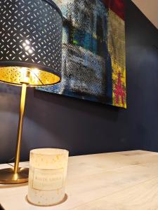 uma lâmpada sobre uma mesa ao lado de uma pintura em Studio Chaleureux em Pont-sur-Seine