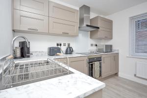 cocina con armarios blancos y lavavajillas en Luxury Duplex 2-Bed Apartment Fruit Market Marina en Hull