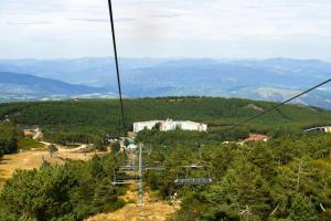 a gondola ride in the mountains with a building in the distance at Manzaneda Natura Apartaments T1 vista montaña in Prada