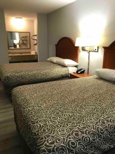 a hotel room with two beds and a mirror at Walnut Inn - Checotah in Checotah