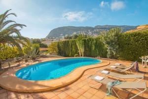 basen z 2 krzesłami, stołem i 2 palcami w obiekcie Villa Tran - Plusholidays w mieście Calpe