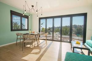 jadalnia ze stołem i krzesłami oraz dużym oknem w obiekcie Villa Tran - Plusholidays w mieście Calpe