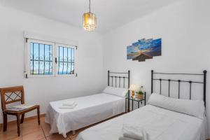 a bedroom with two beds and a chair and windows at Villa Rodrigo - PlusHolidays in Benissa +22 photos
