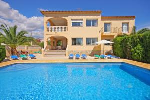 a villa with a swimming pool in front of a house at Villa Senieta - PlusHolidays in Calpe