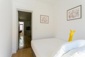Dormitorio blanco con cama y pasillo en City Retreat, en Lisboa