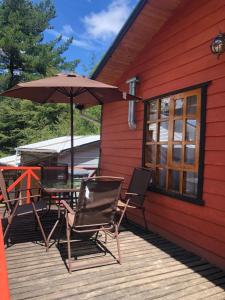 einen Tisch und Stühle auf einer Terrasse mit einem Sonnenschirm in der Unterkunft Cabaña 1 Crucerito in Castro