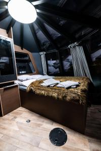 um quarto com uma cama numa carrinha com um candeeiro em Yggdrasil Igloo Värmland em Töcksfors
