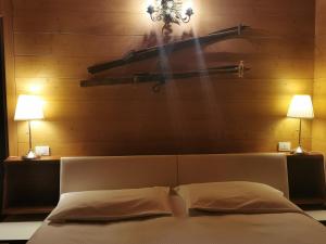 a bedroom with a bed with two lights on the wall at Chalet nel bosco in Borca di Cadore