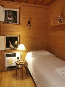 a bedroom with two beds and a tv and a table at Chalet nel bosco in Borca di Cadore